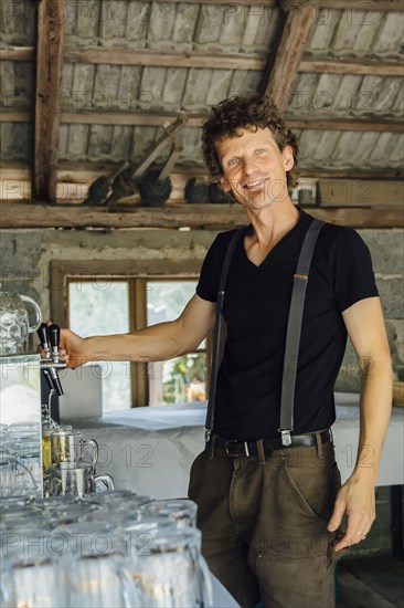 Caucasian man pouring beer into glass at restaurant