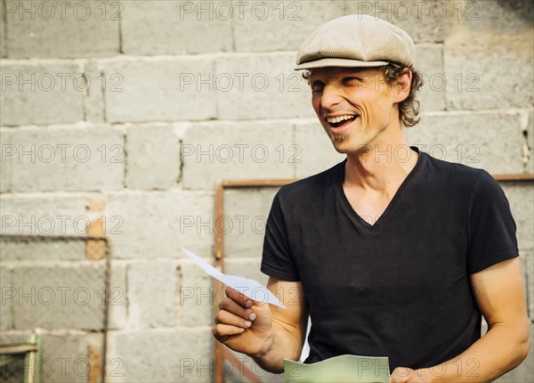 Smiling Caucasian man holding paper