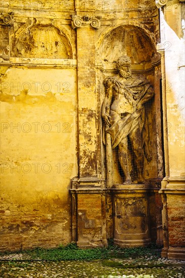 Worn statue in alcove