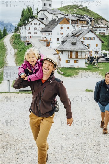 Caucasian father carrying daughter