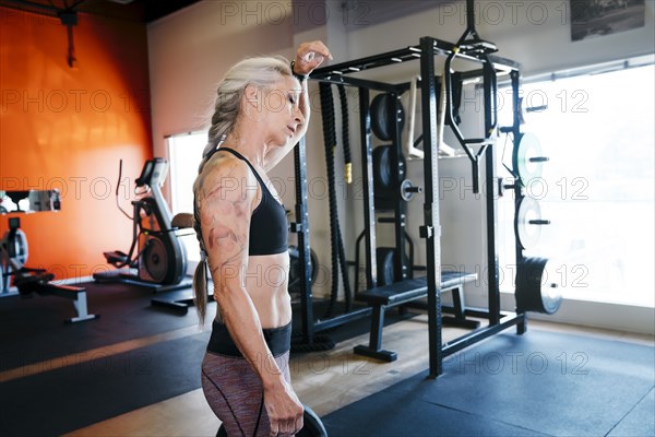 Caucasian woman sweating in gymnasium