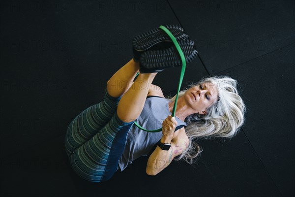 Caucasian woman stretching leg with resistance band