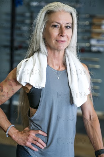 Caucasian woman posing in gymnasium wearing towel