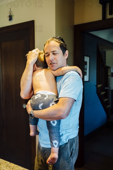 Father holding and comforting son