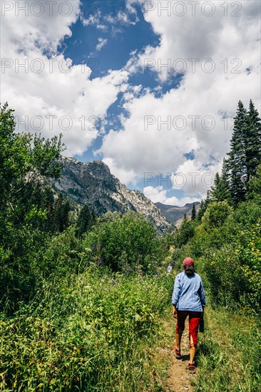 Caucasian woman hiking on path in mountains