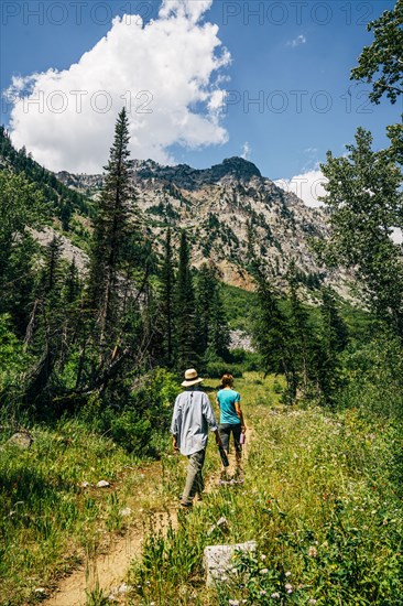 Caucasian couple hiking on path in mountains