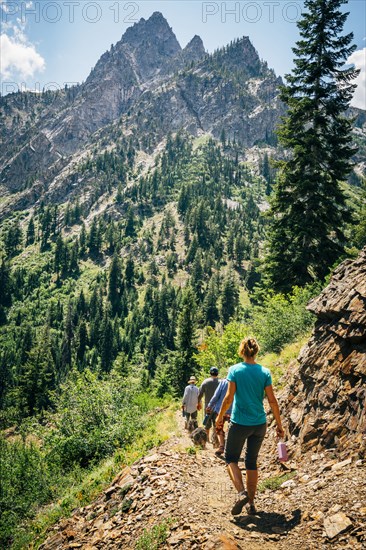 Caucasian people hiking on path in mountains