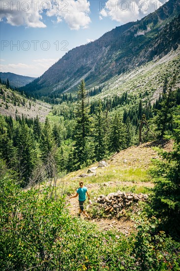 Caucasian woman hiking downhill on path in mountains