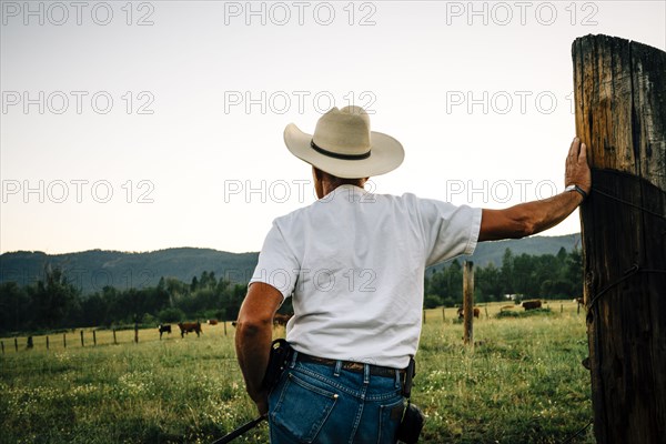 Caucasian farmer leaning on wooden post