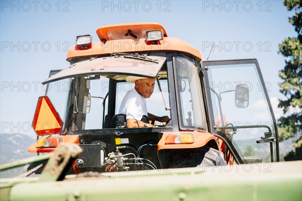 Caucasian farmer driving tractor