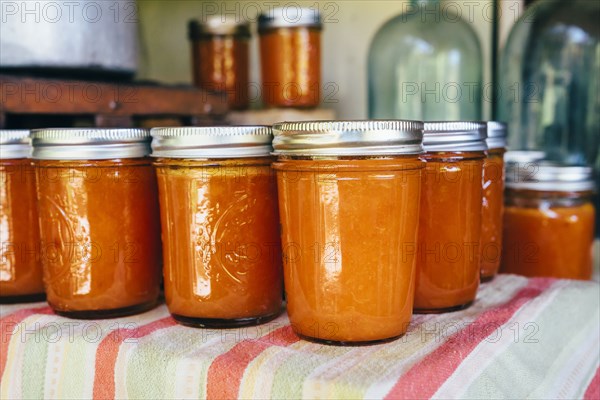 Jars of peach jam on table