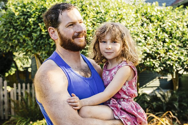 Portrait of Caucasian father carrying daughter