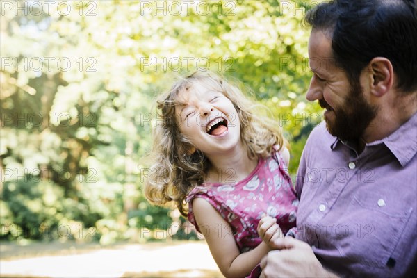 Caucasian father carrying laughing