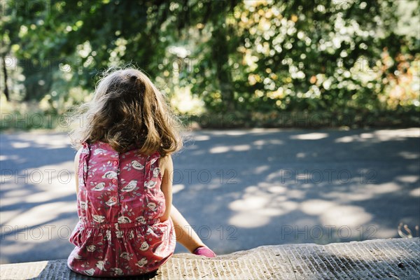 Caucasian girl sitting on curb