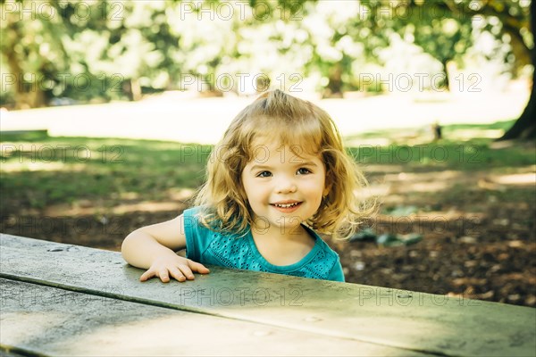 Portrait of Caucasian preschool girl at picnic table
