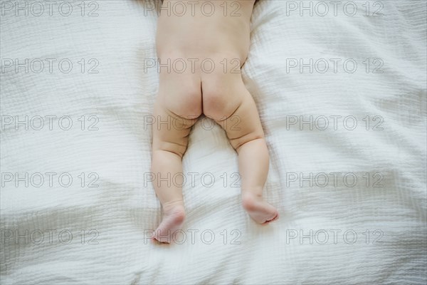 Naked buttocks of Mixed Race baby girl laying on blanket