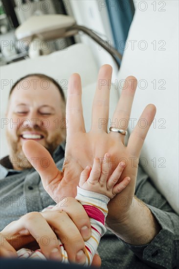 Father high-fiving baby daughter