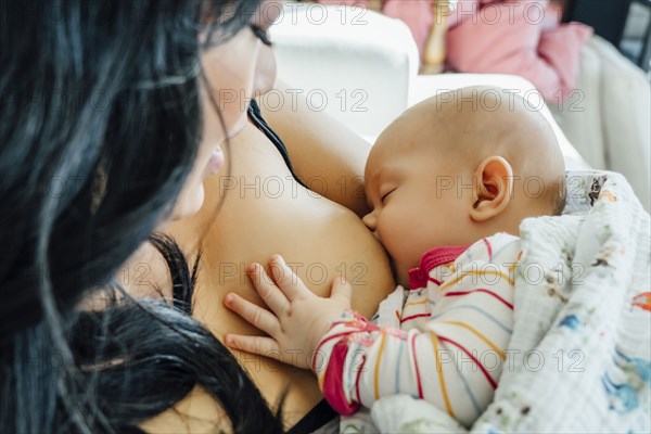 Mother breast-feeding baby daughter