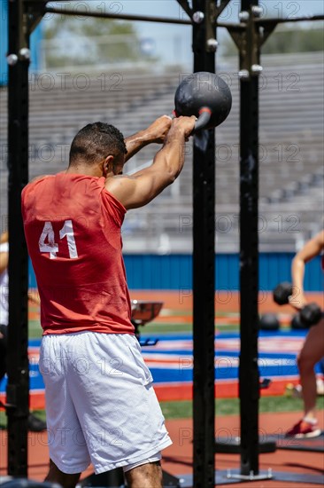 Man lifting kettlebell outdoors