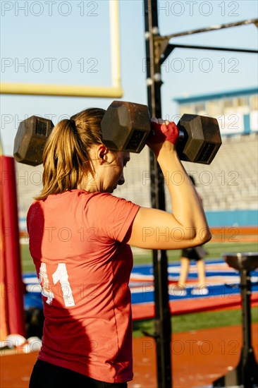 Caucasian woman lifting weights outdoors