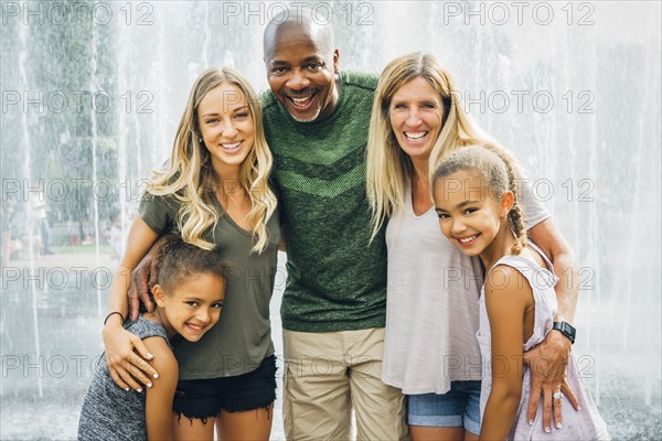 Multi-ethnic family posing near fountain