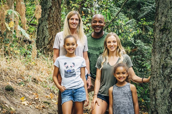 Multi-ethnic family posing in forest