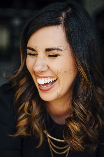 Portrait of laughing Mixed Race woman with pierced nose