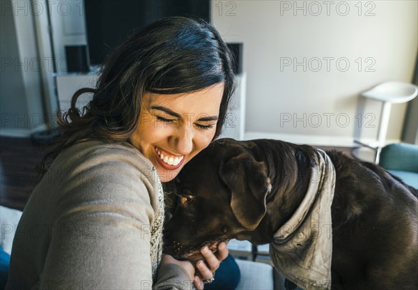 Mixed Race woman hugging dog