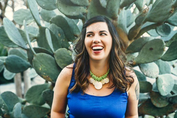 Smiling Mixed Race woman near cactus