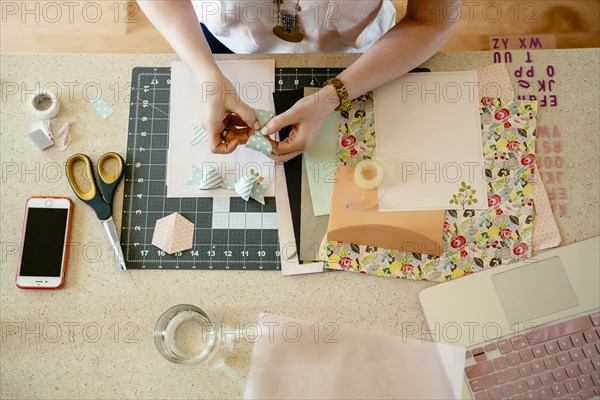 Hands of woman making bow on table