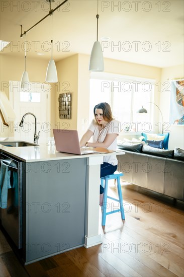 Woman sitting at counter using laptop