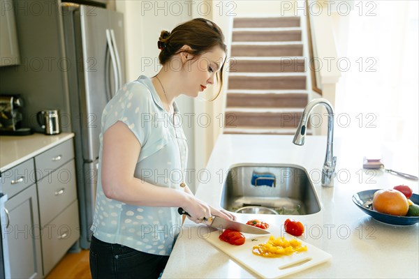 Woman chopping food in domestic kitchen