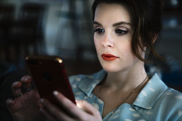 Woman texting on cell phone in the dark