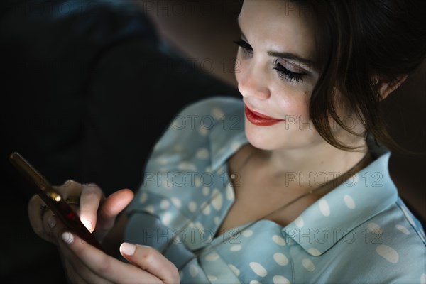 Woman texting on cell phone in the dark