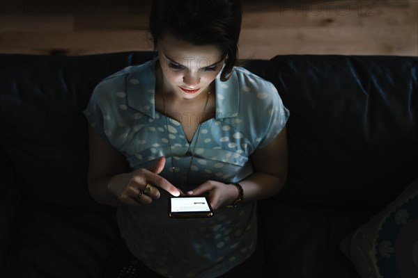 Woman texting on cell phone in the dark