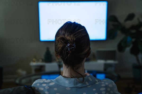 Woman watching television in the dark