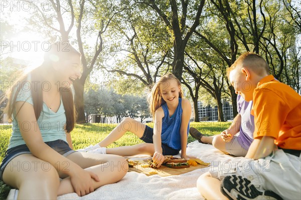 Smiling Caucasian family eating food at picnic