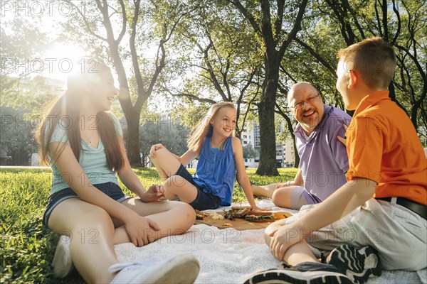 Smiling Caucasian family eating food at picnic