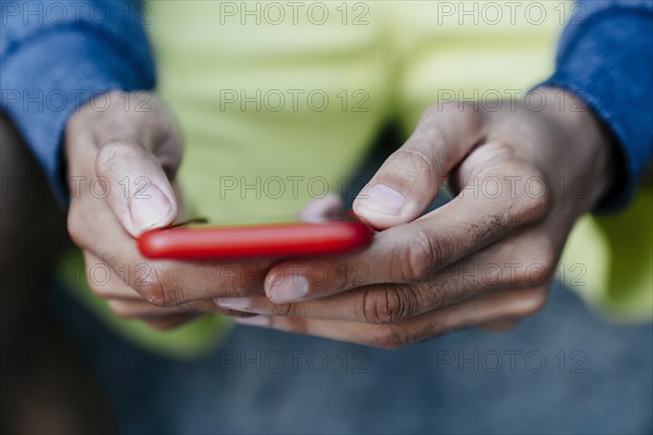 Hands of Black man texting on cell phone