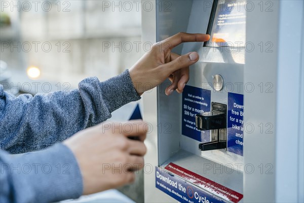 Hands of Black man paying at kiosk with credit card