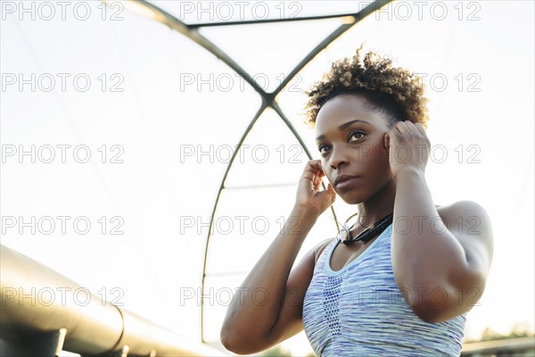 Mixed Race woman adjust earbuds