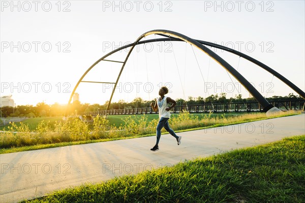 Mixed race woman running on path in park