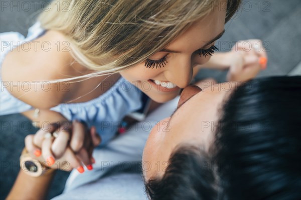 Smiling Caucasian couple holding hands and rubbing noses