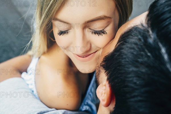 Caucasian man hugging woman and kissing her on cheek