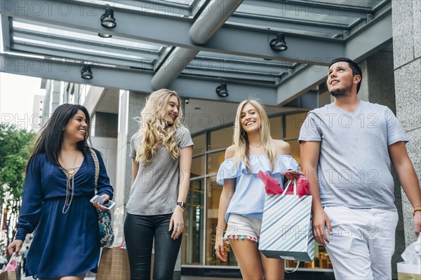 Friends carrying shopping bags in city