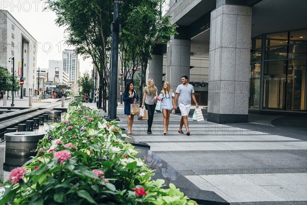 Friends carrying shopping bags in city