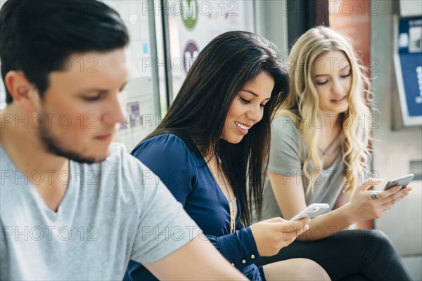 Women texting on cell phones at train station