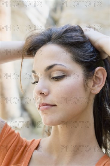 Hispanic woman lifting hair