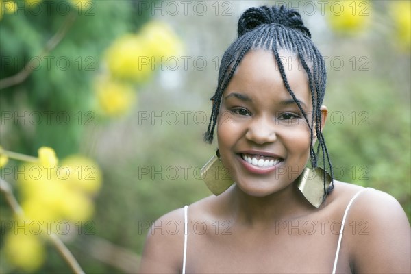 Mixed race woman wearing earrings smiling