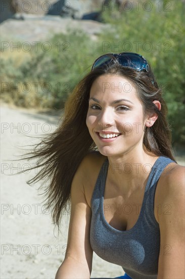 Hispanic woman with sunglasses smiling